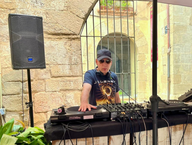 Photo of Paul Castro behind a set of decks.