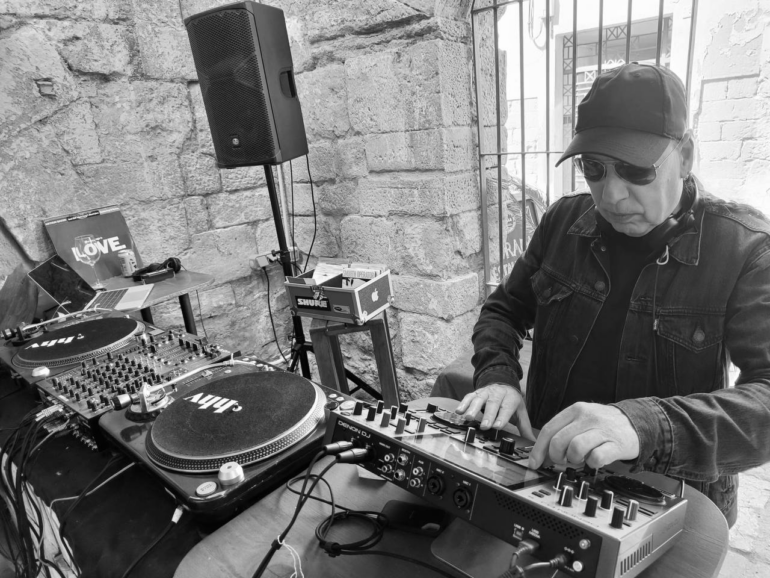 Black and white photo of Paul Castro behind a mixing desk.